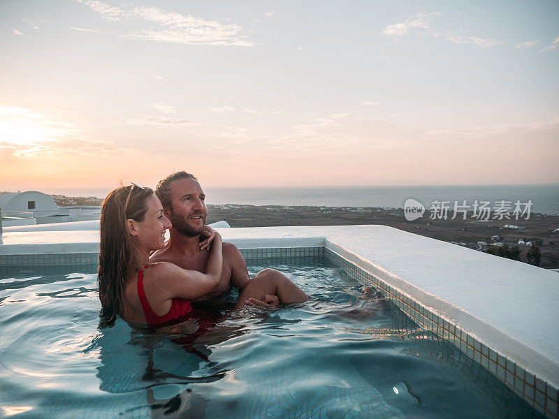 海景，日落时分，年轻夫妇在热水浴缸里放松