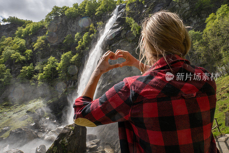 女人热爱自然，她用双手在瀑布上做了一颗心