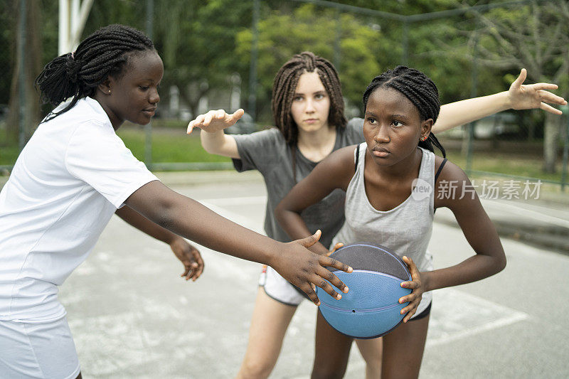 多种族的女孩在认真地打篮球