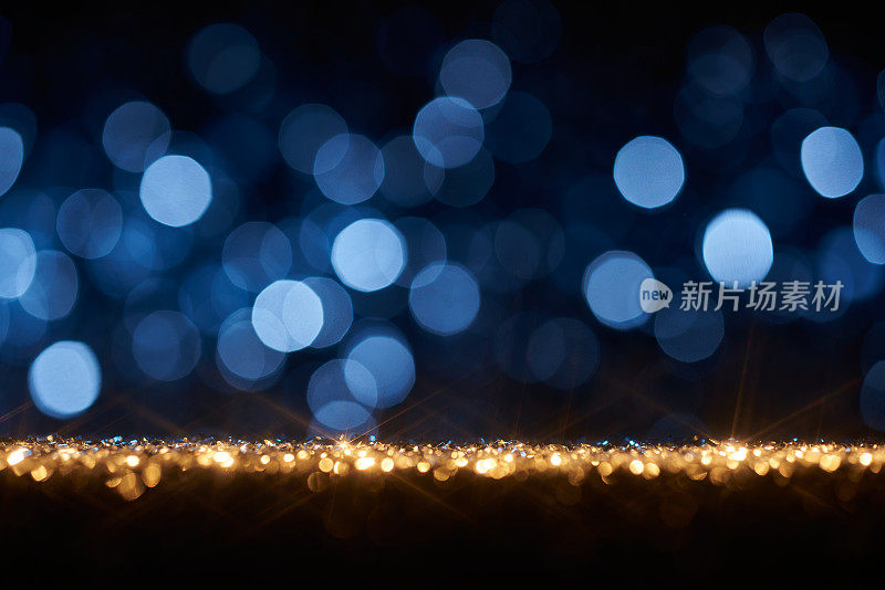 金色的闪光和蓝色的散焦灯背景-圣诞节，节日，庆祝