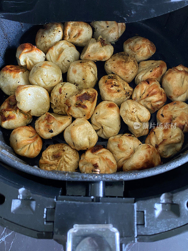 特写图片Momos(南亚饺子)，白面粉和水面团填充鸡肉和混合蔬菜在空气炸锅煮，更健康的替代煎锅，高架视野，聚焦前景