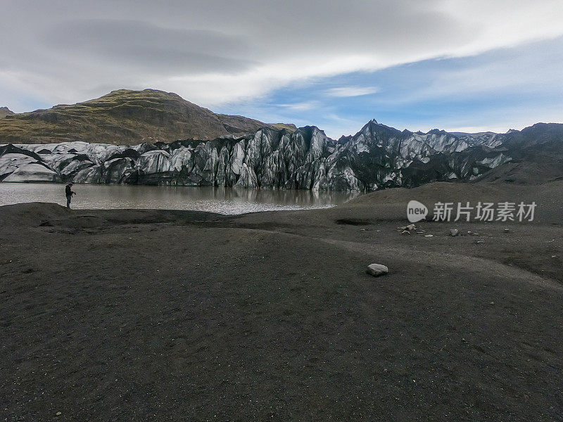 一名男子在冰岛的徒步旅行路线上看着冰川泻湖