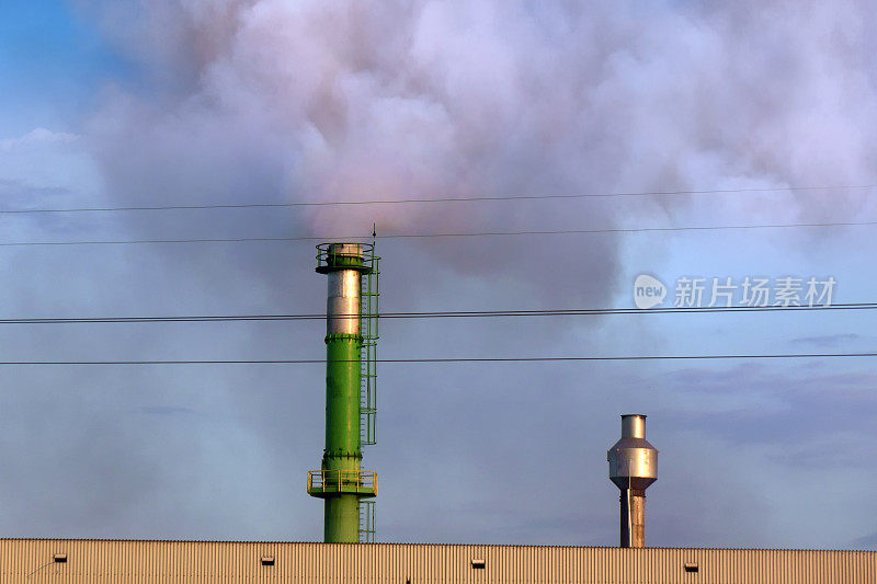 高大的工厂烟囱和烟雾笼罩着天空