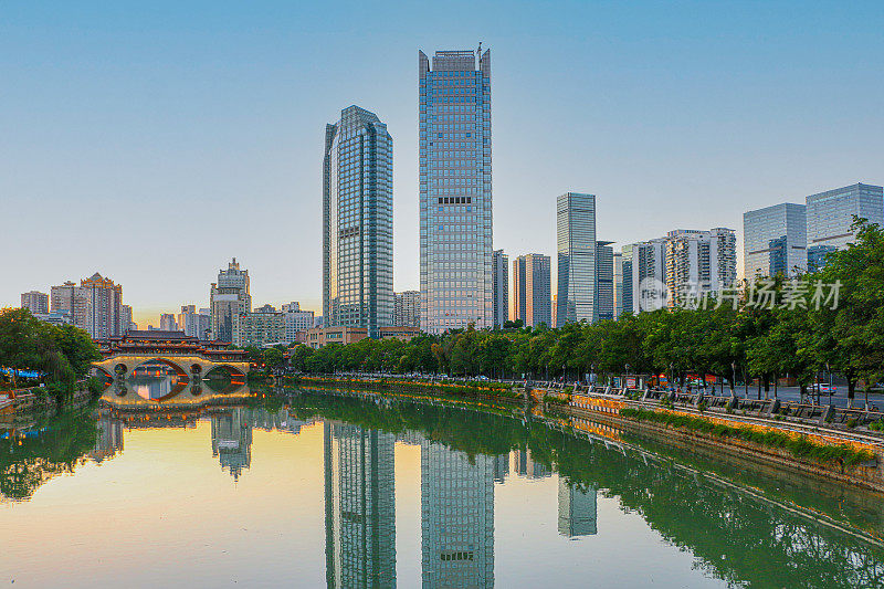 落日余晖俯瞰着成都著名的风景，背景是锦江上的安顺大桥和现代化的摩天大楼
