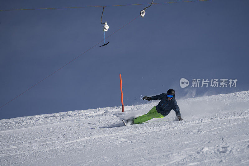 男子在滑雪板上切割滑雪坡