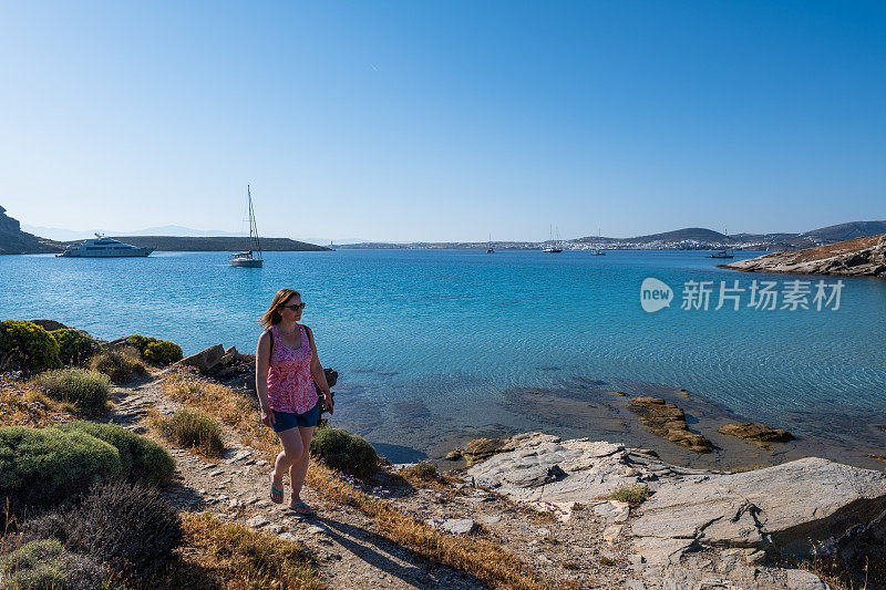 女旅行者探索平静的海湾边缘