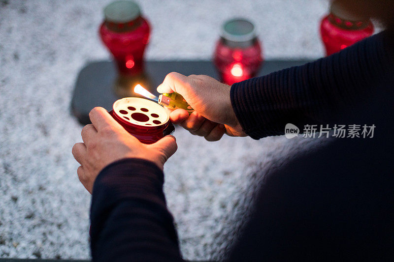 在万圣节和基督徒的手拿着纪念的烛光在墓地