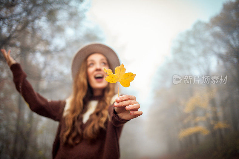 美丽的年轻女子在秋天走在户外的画像