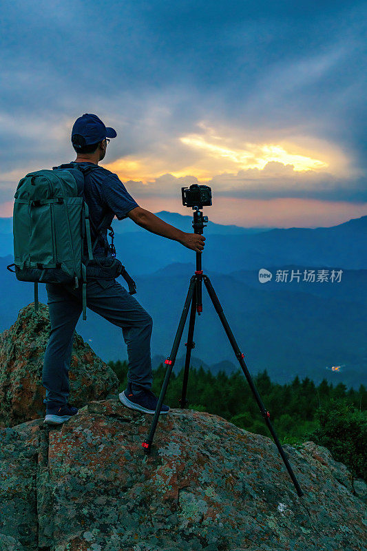 摄影师在夜晚的山顶上拍摄“r”