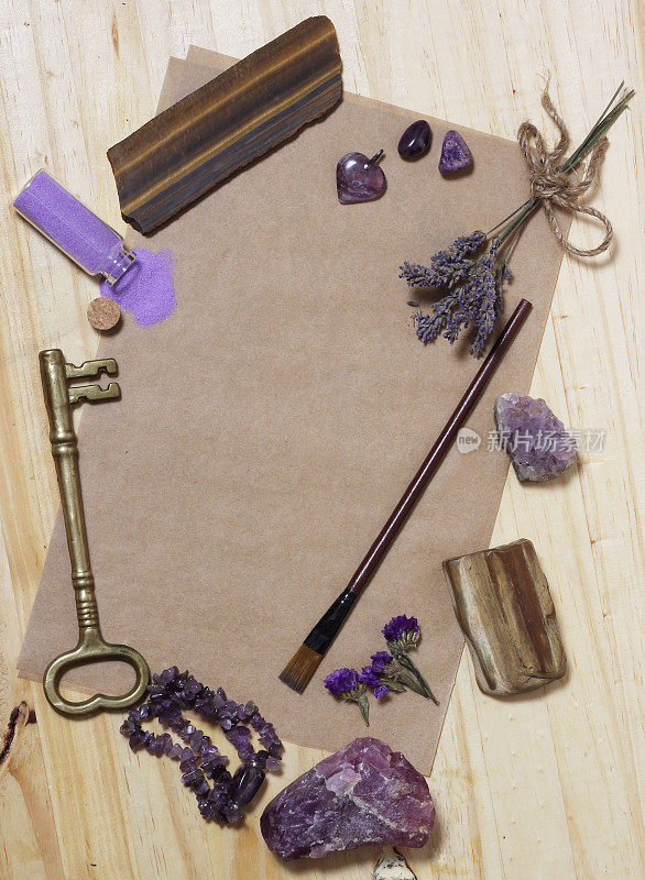 紫水晶石与石化木在旧纸与干花和钥匙。紫色主题背景