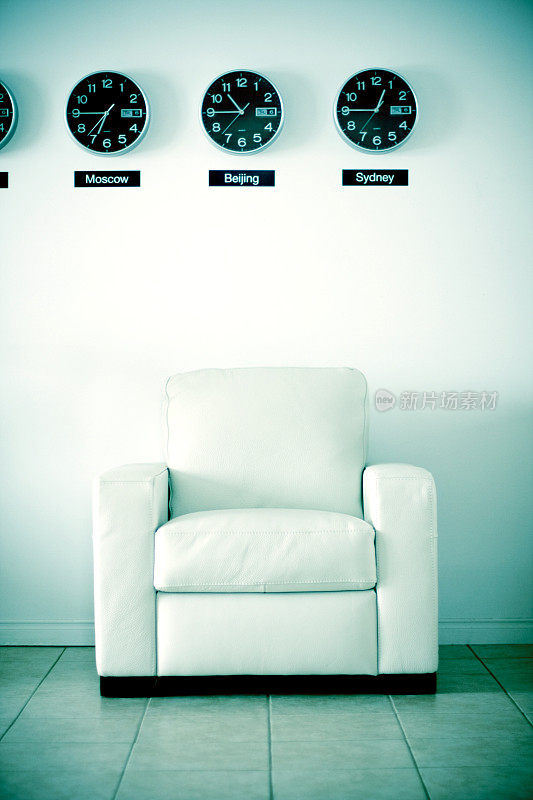世界时间钟表下面的白色办公椅