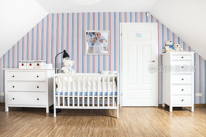 小婴儿的房间，白色的家具，红蓝条纹的墙纸