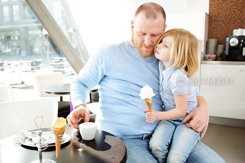 父亲和女儿在咖啡馆吃冰淇淋