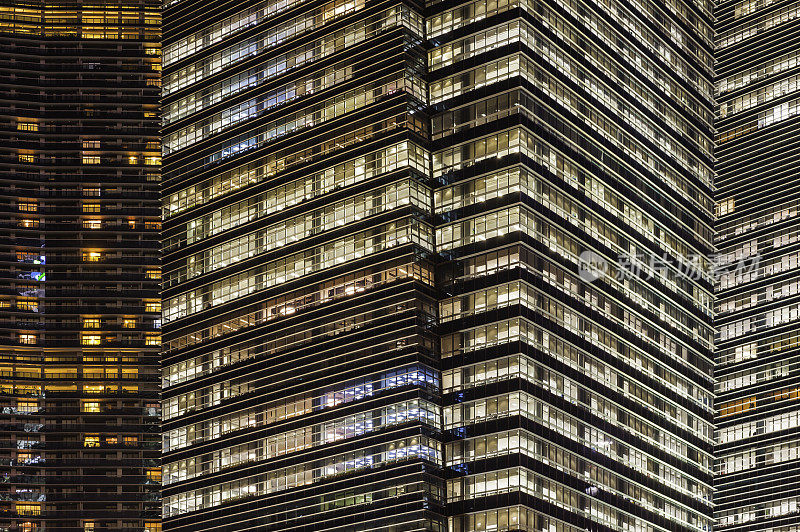 温暖的灯光照亮了新加坡摩天大楼的高层办公大楼窗户