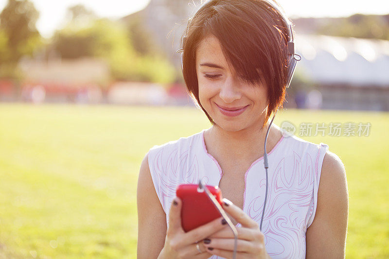 年轻女子在用智能手机听音乐