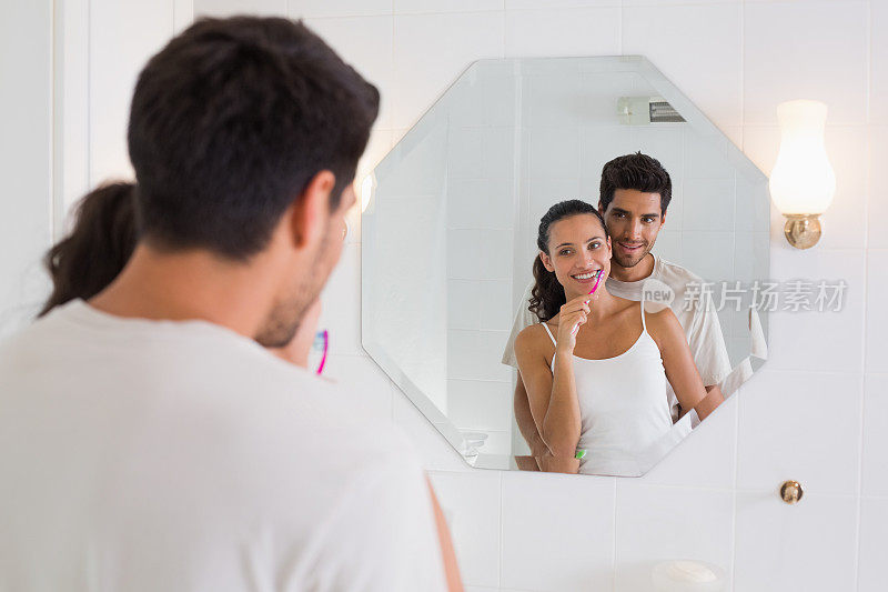 男朋友和女朋友在浴室镜子前刷牙