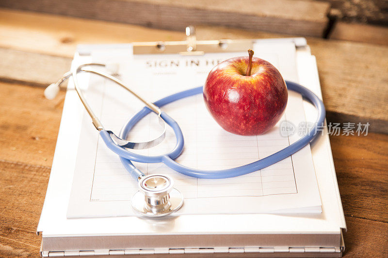 苹果，医生办公室登记表上的听诊器。健康的生活方式。
