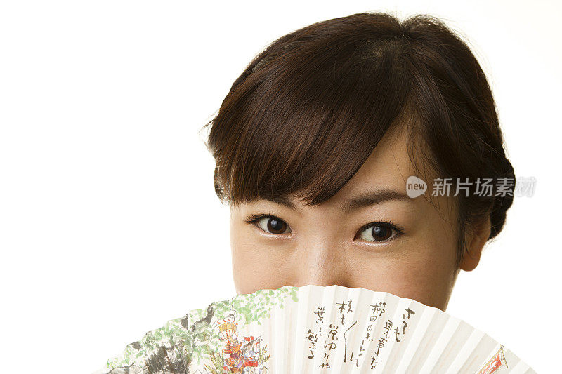 一名日本妇女把脸藏在纸扇后面
