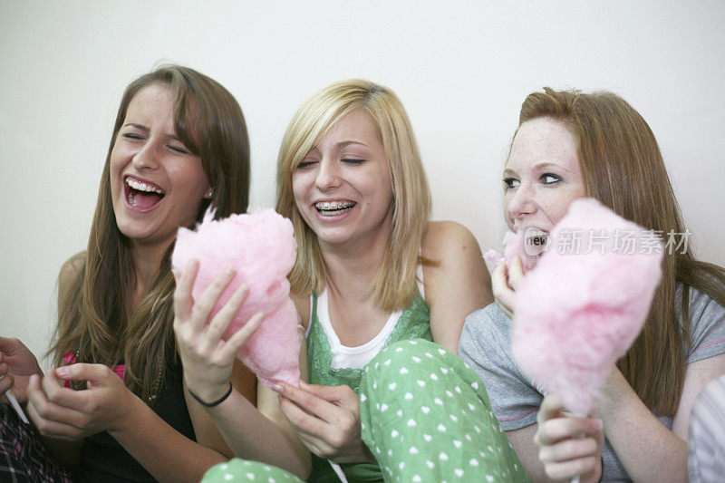 女性朋友在吃粉色棉花糖时大笑