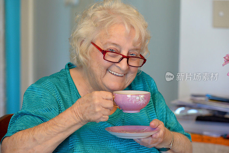 一个快乐的老太太，老花镜和一杯茶