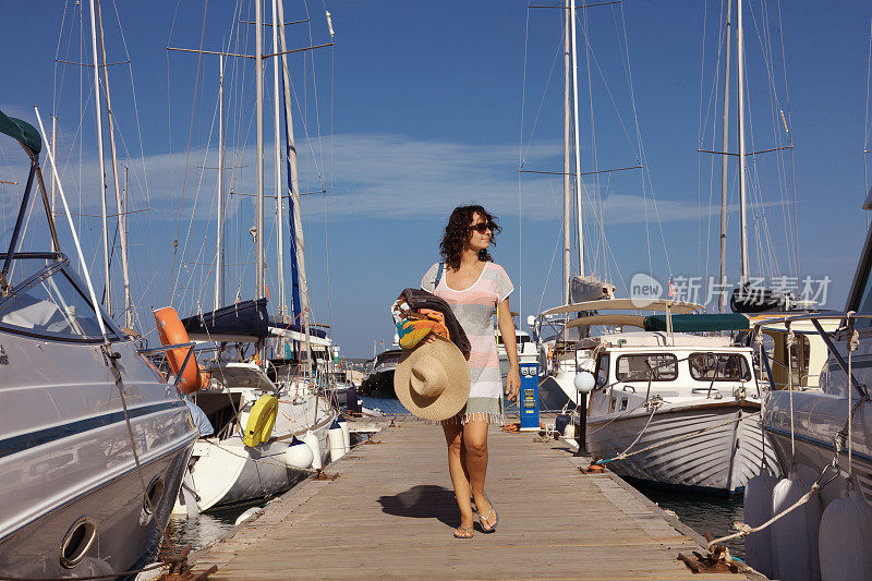 年轻女子在游艇码头散步