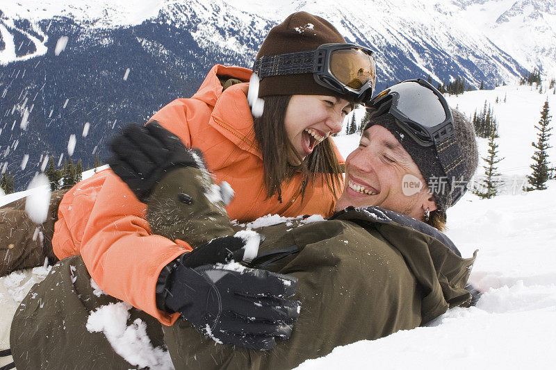 年轻夫妇在雪中玩耍。