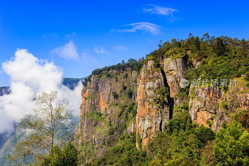 科迪卡纳尔，泰米尔纳德邦，印度-一个罕见的无雾的柱状岩石的背景下，蓝天和低白云。这是一个经常被参观的旅游景点。