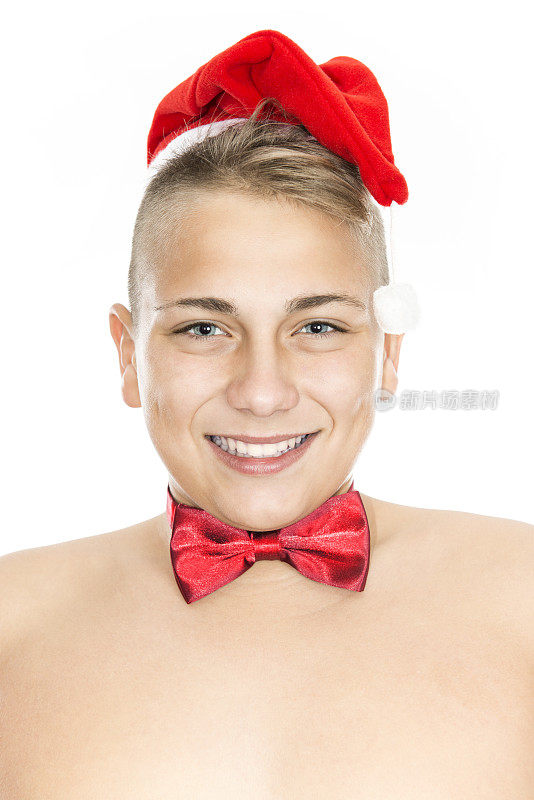可爱的少年男孩与圣诞老人帽和红色蝴蝶结