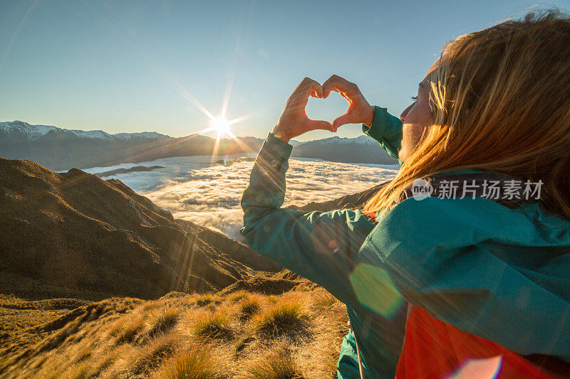 山顶上的女人为山水做了心形框架