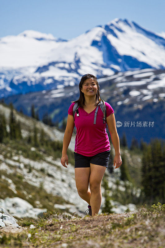 年轻的亚洲女子在山里徒步旅行。