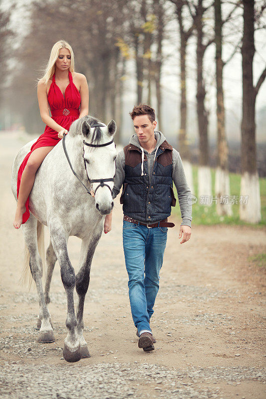 漂亮的女孩和英俊的男人骑着白马