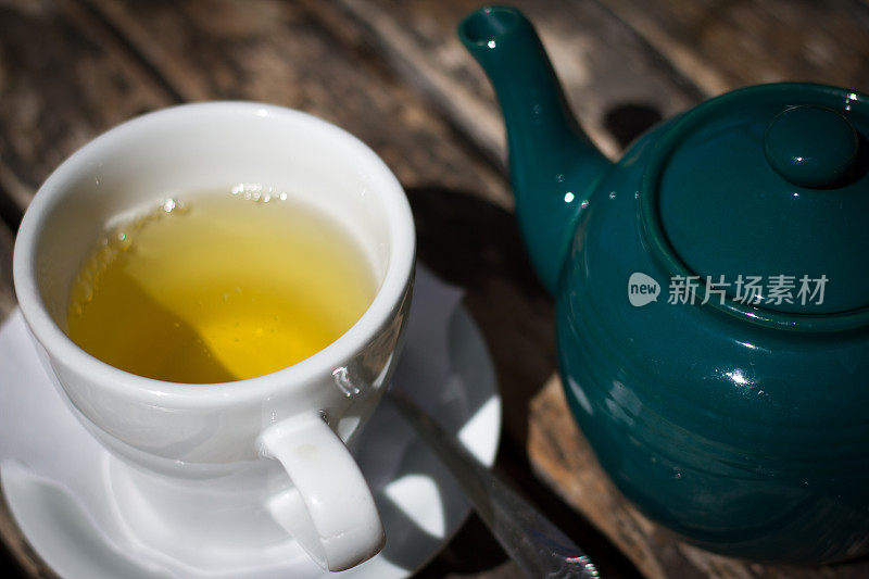 一杯花草茶和绿色茶壶(特写)