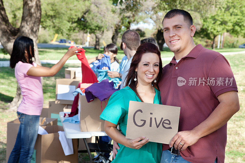 一对夫妇在捐赠中心举着“给予”的牌子