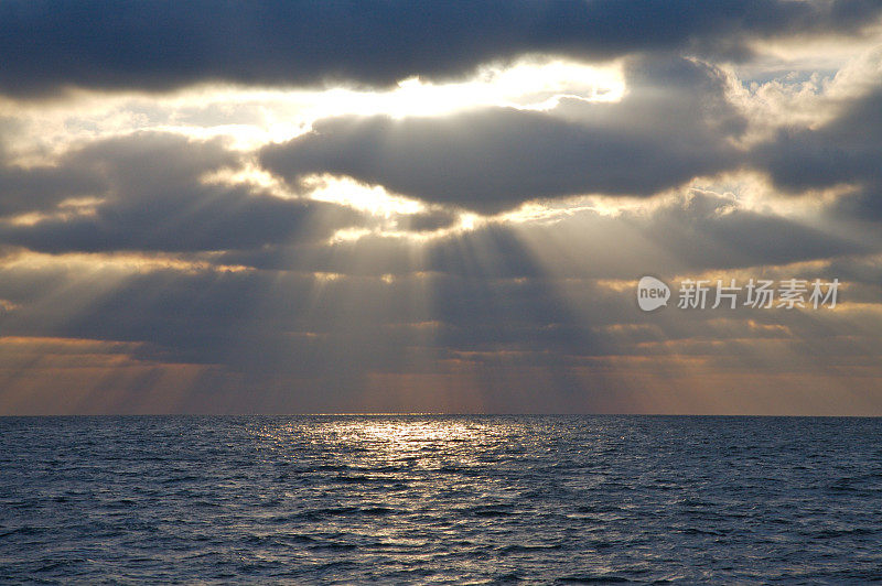 太阳躲在云后面，越过海面