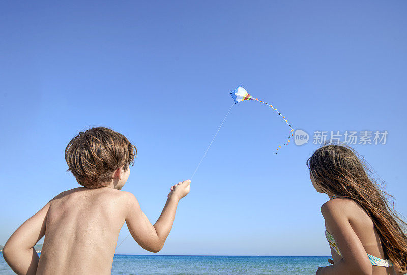 男孩和女孩在海滩上放风筝