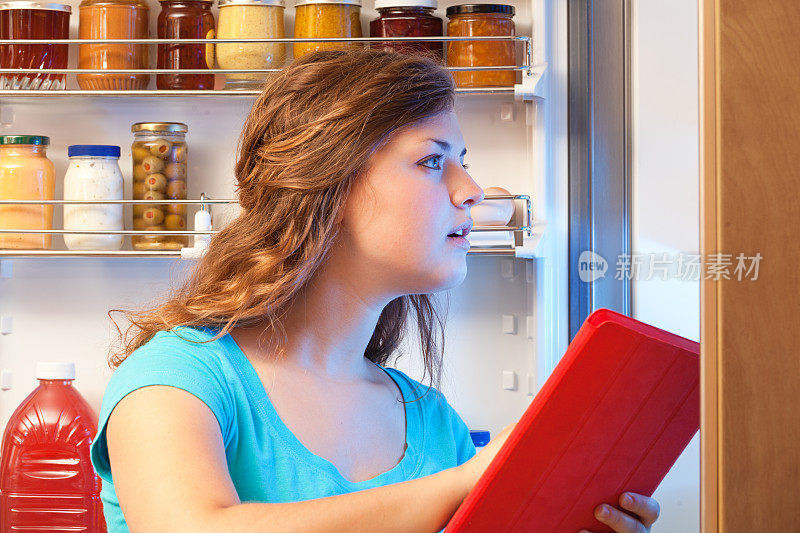 女人在冰箱前购物，在网上购物杂货店
