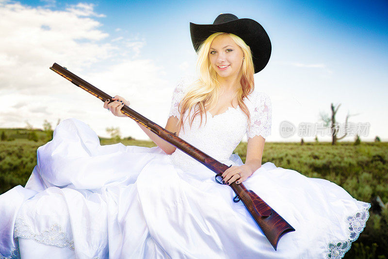 在蒙大拿州的灌木丛中，手持猎枪的女牛仔新娘