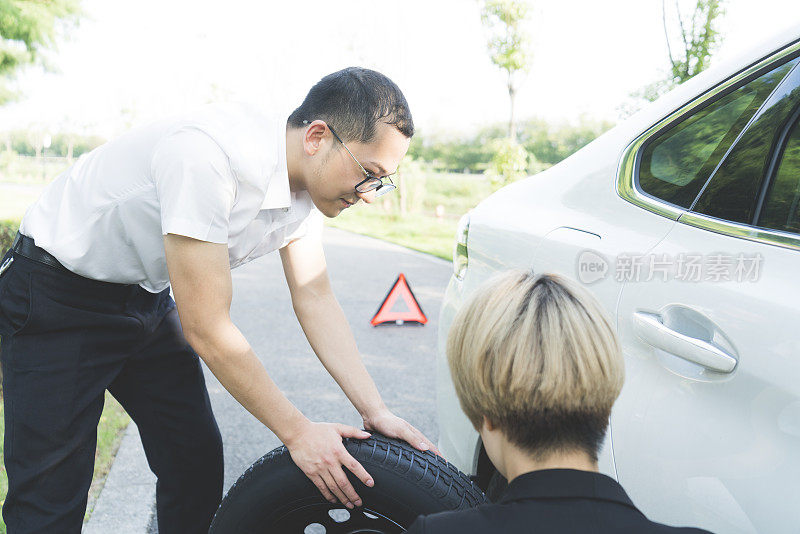 男男女女在路边换轮胎