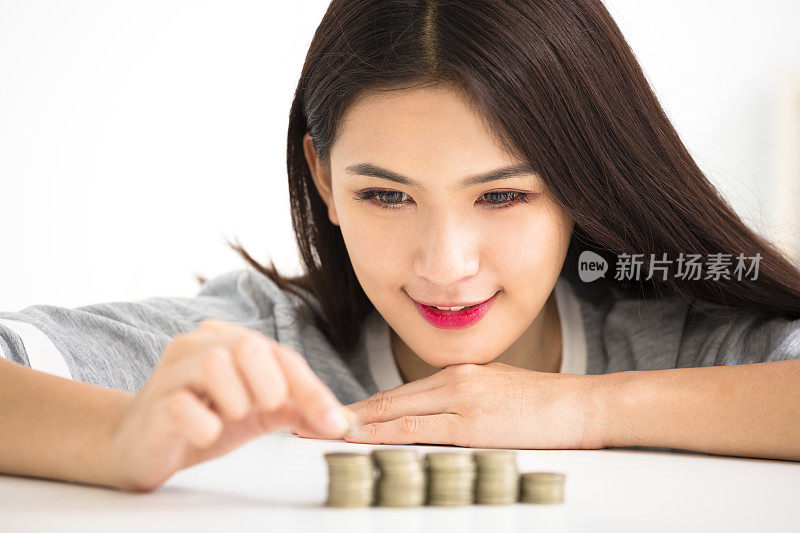 年轻女子把硬币堆起来，省钱理念