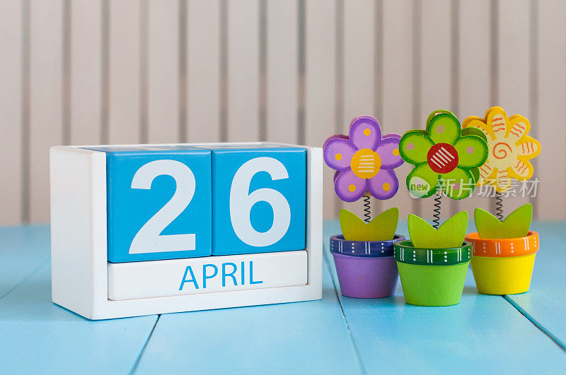 4月26日。图片4月26日木制彩色日历上的白色背景与鲜花。春日，空为文字