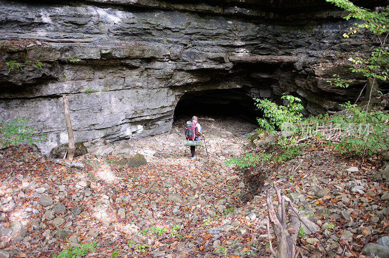 年轻女子徒步向洞穴入口走去
