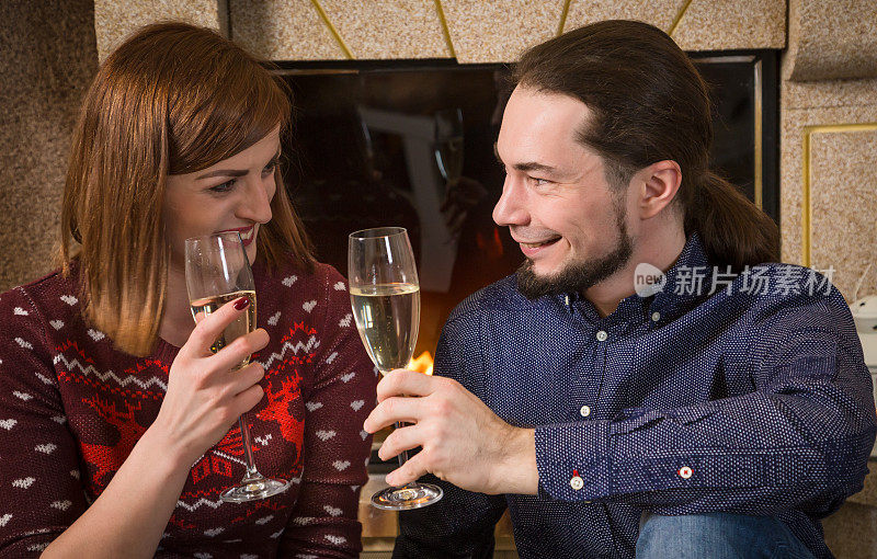 情侣们在壁炉旁一起喝香槟
