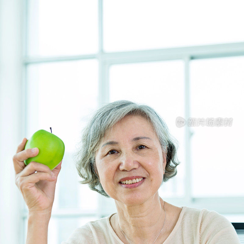 家里拿着苹果的老妇人