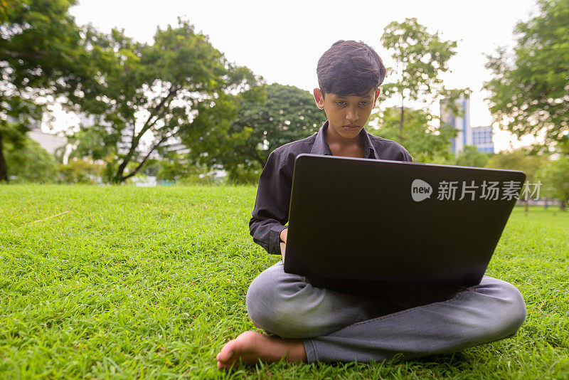 年轻的印度男孩在泰国曼谷的朗菲尼公园放松的肖像