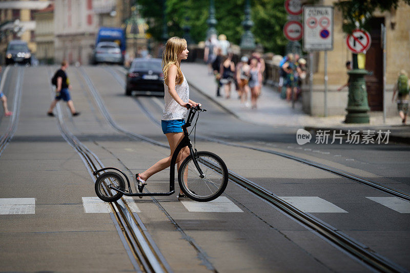 夏日城市布拉格，骑着自行车的女孩在斑马线上