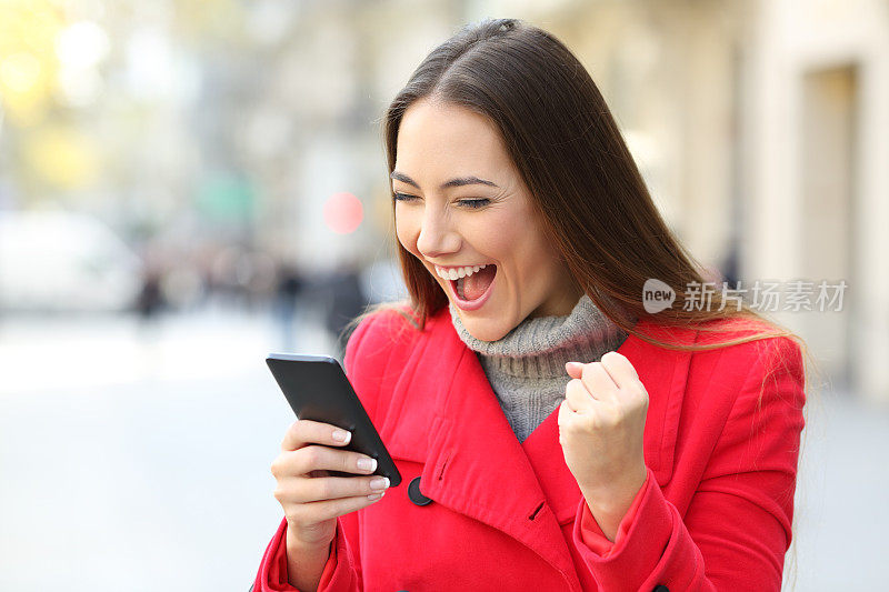 在冬天的街道上，兴奋的女人在网上获胜