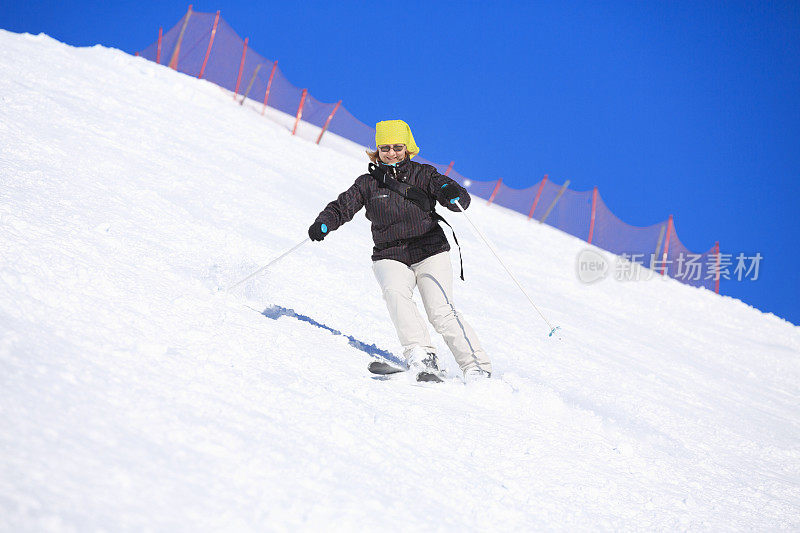 业余冬季运动女子滑雪者滑雪在阳光明媚的滑雪胜地Dolomites在意大利
