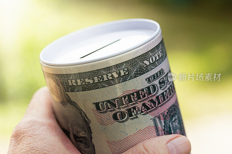 手握收集罐或硬币银行与美元钞票设计