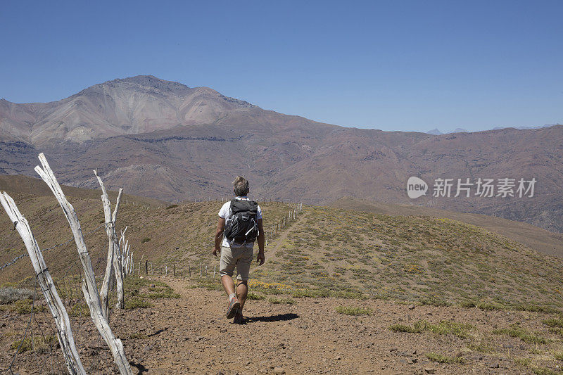 查看过去的木栅栏桩，徒步在沙漠小径在山区