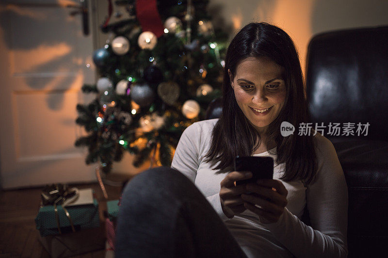 年轻女子在圣诞夜使用手机